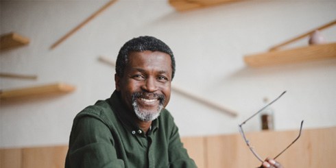 man smiling while sitting at table