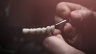 Lab technician paining replacement teeth